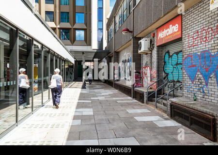 Centre Commercial arcades récemment ouvert, le M&S Food Hall sur la gauche et, en revanche, les couverts de graffitis Metroline cantine sur la droite, Londres, Royaume-Uni, 2019 Banque D'Images