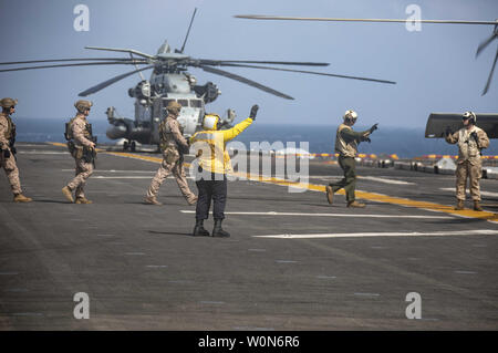 Marines affectés à la 22e Marine Expeditionary Unit (MEU) transit le poste de pilotage de la classe Wasp-navire d'assaut amphibie USS Kearsarge LHD (3) d'entreprendre une Sea Hawk MH-60S pour effectuer visite, conseil, recherche et la saisie de la formation sur la classe Arleigh Burke destroyer lance-missiles USS Bainbridge (DDG 96) le 17 mai 2019. L'Abraham Lincoln (ABECSG) et groupe amphibie Kearsarge (KSGARG) mènent des opérations conjointes dans la 5e flotte américaine zone d'opérations. Le ABECSG KSGARG et, avec l'entrepris 22e MEU, sont prêts à faire face aux imprévus et de défendre Banque D'Images