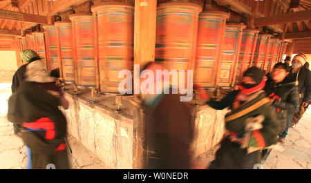 Les nomades tibétains, les pèlerins et les moines, tourner les roues de prière colorés entourant le monastère de Labrang, le plus grand monastère tibétain à l'extérieur de Lhassa, avant le Festival Monlam tibétaine Xiahe, dans la province de Gansu, sur le plateau tibétain, le 2 février 2012. Des dizaines de milliers de Tibétains célèbrent le Nouvel An tibétain en faisant leur chemin vers cette ville et son monastère de Labrang, dont la séparation de la région autonome du Tibet fournit une mesure de protection contre les Chinois Han tente de réguler leur culture. UPI/Stephen Shaver Banque D'Images