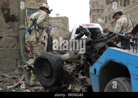 Combattants Houthi inspecter l'épave d'une voiture à l'emplacement d'une attaque près de Qubbat al-Mahdi mosquée de Sanaa, Yémen, le 20 juin 2015. Au moins trois personnes ont été tuées et sept autres personnes ont été blessées lorsqu'une voiture piégée a frappé une mosquée utilisé par le combattants Houthi dans la capitale du Yémen, selon des sources médicales... Photo par Mohammad Abdullah/UPI Banque D'Images