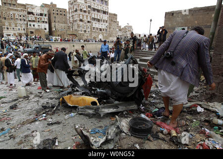 Combattants Houthi inspecter l'épave d'une voiture à l'emplacement d'une attaque près de Qubbat al-Mahdi mosquée de Sanaa, Yémen, le 20 juin 2015. Au moins trois personnes ont été tuées et sept autres personnes ont été blessées lorsqu'une voiture piégée a frappé une mosquée utilisé par le combattants Houthi dans la capitale du Yémen, selon des sources médicales... Photo par Mohammad Abdullah/UPI Banque D'Images