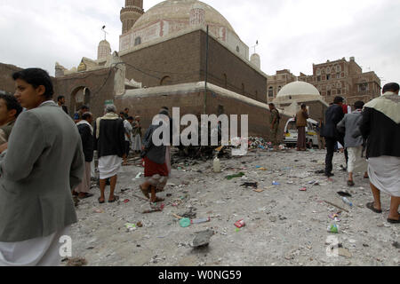 Combattants Houthi inspecter l'épave d'une voiture à l'emplacement d'une attaque près de Qubbat al-Mahdi mosquée de Sanaa, Yémen, le 20 juin 2015. Au moins trois personnes ont été tuées et sept autres personnes ont été blessées lorsqu'une voiture piégée a frappé une mosquée utilisé par le combattants Houthi dans la capitale du Yémen, selon des sources médicales... Photo par Mohammad Abdullah/UPI Banque D'Images