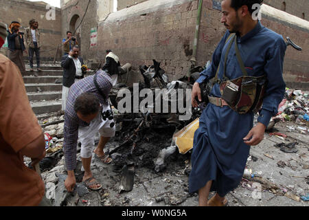 Combattants Houthi inspecter l'épave d'une voiture à l'emplacement d'une attaque près de Qubbat al-Mahdi mosquée de Sanaa, Yémen, le 20 juin 2015. Au moins trois personnes ont été tuées et sept autres personnes ont été blessées lorsqu'une voiture piégée a frappé une mosquée utilisé par le combattants Houthi dans la capitale du Yémen, selon des sources médicales... Photo par Mohammad Abdullah/UPI Banque D'Images