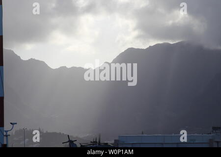 La lumière du soleil qui sur les montagnes à Hawaii Kai, Hawaii sur l'île d'Oahu. Il apparaît comme la lumière de Dieu brille à travers les nuages. Banque D'Images