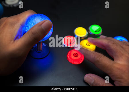 Arcade gamer à l'aide d'un joystick et bouton lumineux de chasse mise en page avec neo geo de couleurs. Banque D'Images