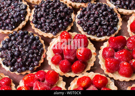 Close up of fresh fruits d'été dans un tartelettes sur un fond de bois. Banque D'Images