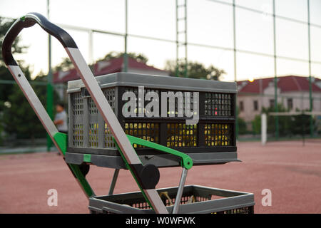 Chariot pour balles de tennis sur le court de tennis en soirée Banque D'Images