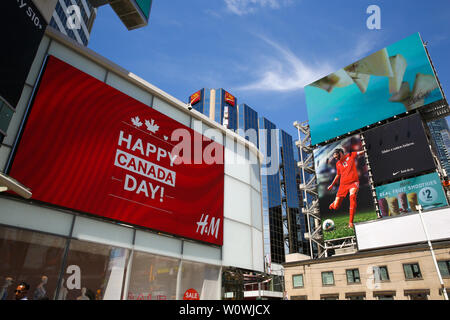 Une 'Bonne fête du Canada' affichage LED visibles à l'extérieur le magasin H & M que la ville se prépare à célébrer la fête du Canada 152th à Toronto. Banque D'Images