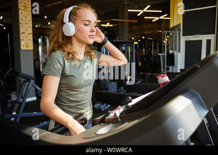 Fille termine la cardio- formation sur le tapis roulant. Banque D'Images