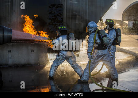 Avec les Marines américains de sauvetage et de lutte contre les incendies d'aéronefs (SLIA), du siège et de l'Escadron (H&HS), Marine Corps Air Station Yuma (MCAS) conduite part vivre pendant les exercices en ligne formation gravure sur MCAS Yuma (Arizona), le 25 juin 2019. Ligne à main l'accent sur les exercices techniques pour pousser les feux de carburant de l'avion, train Marines SLIA pour améliorer mensuel leur état de préparation en vue de répondre à des urgences sur la ligne de vol. (U.S. Marine Corps photo par Lance Cpl. John Hall) Banque D'Images