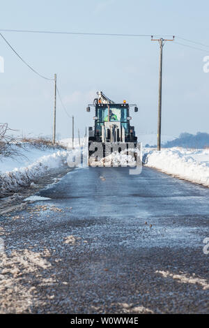 Déneigement tracteur loin d'une route de campagne Banque D'Images