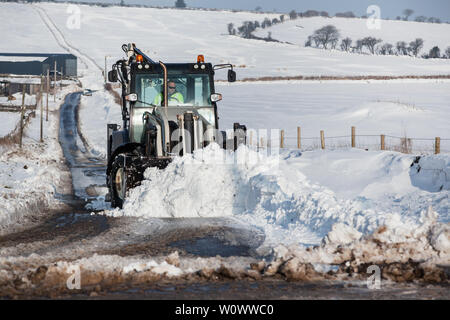 Déneigement tracteur loin d'une route de campagne Banque D'Images