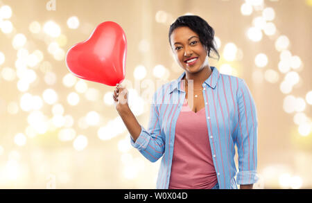 African American Woman with heart-shaped balloon Banque D'Images