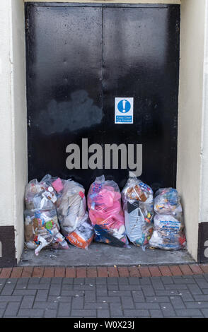 Kilkenny, Irlande, mai, 10, 2019 : sacs de sacs en plastique transparent pile dans une porte qui est une issue de secours, d'une personne dans l'image Banque D'Images