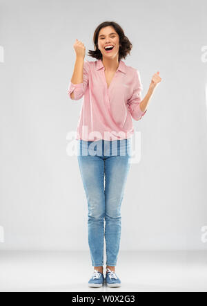 Jeune femme en jeans et chemise des succès à célébrer Banque D'Images