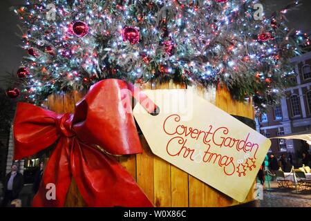 Londres/UK - 27 novembre 2013 : vue d'arbre de Noël traditionnel de la Covent Garden Square dans un tonneau en bois décoré d'arc rouge. Banque D'Images