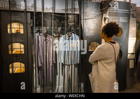 Vue d'une femme à la recherche de vêtements portés par les détenus du camp de concentration nazi sur l'affichage dans le musée de la résistance norvégienne dans le centre d'Oslo, Norvège. Banque D'Images