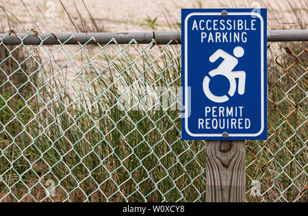 Permis de stationnement accessible panneau requis sur un poteau de bois en face des dunes pour les personnes handicapées de se garer à la plage. Banque D'Images