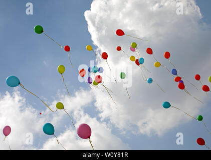 De nombreux ballons colorés voler haut dans le ciel bleu après l'événement Banque D'Images