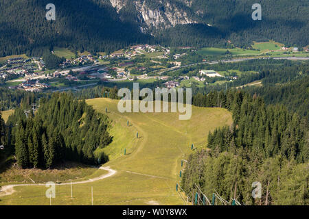 Pente de ski avec de vertes prairies en été (Monte Lussari). En aval du petit village de Bordighera à Valcanale, Tarvisio, Friuli, Italie Banque D'Images