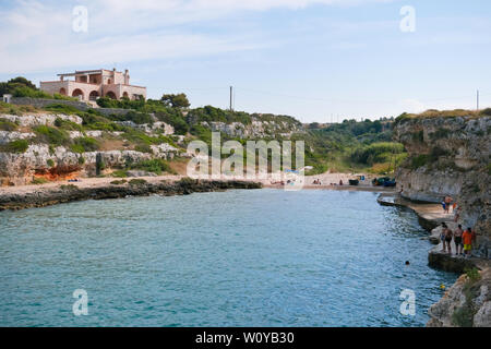 Monopoli, Italie ; méconnaissable de personnes sur la plage de la Fisherman's bay dans le territoire de Monopoli un après-midi de l'été dans le temps libre. Banque D'Images