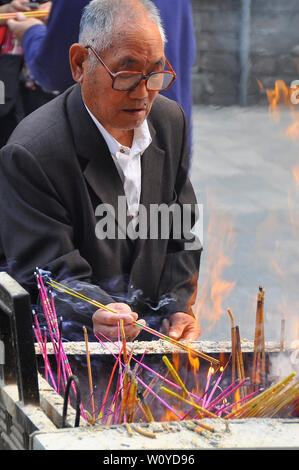 Adorateur brûler des parfums offerts au temple bouddhiste à Beijing Banque D'Images