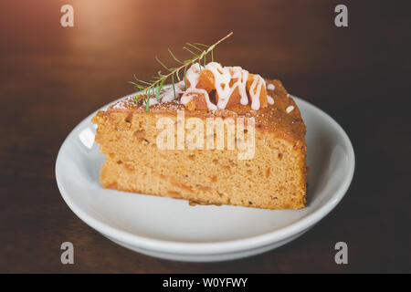 Gâteau de fruit en pause café servent de coupe en plaque blanche avec un éclairage chaleureux. Banque D'Images