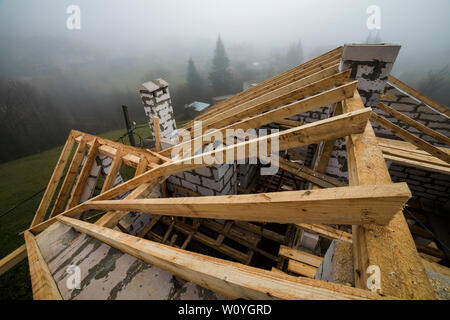 Vue de dessus du châssis de toit en bois poutres de bois et de planches sur les parois en blocs isolants en mousse creux. Bâtiment, construction, toitures et renovat Banque D'Images