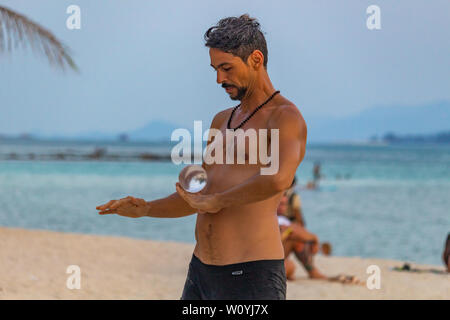 Koh Phangan, Thaïlande - 26 Avril 2019 : l'homme jouant avec un contact juggling ball sur le Zen beach au coucher du soleil sur l'île de Koh Phangan Banque D'Images