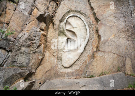 Allégement monumentale 'Barber's Ear' (Bretschneiderovo ucho) sculpté par le sculpteur tchèque Radomír Dvořák (2005) dans la carrière abandonnée près de Lipnice nad Sázavou En Vysočina, République tchèque. Le relief est l'un des trois qui soulage le Monument National de l'espionnage (Národní památník odposlechu) situés dans trois carrières à proximité. L'agent de police a été Bretschneider l'un des personnages du célèbre roman satirique Le bon soldat Švejk romancier tchèque Jaroslav Hašek par, qui a passé en dernier mois de sa vie et est mort à Lipnice nad Sázavou. Banque D'Images