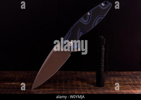 Couteau avec un manche bleu. Belle photo du couteau et lampe de poche. Un couteau dans un état pend. Banque D'Images