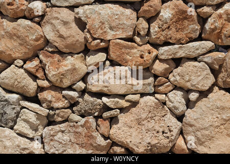 Mur de pierre beige naturel (maçonnerie) créé par l'empilement des pierres les unes sur les autres avec des tailles de pierre. Banque D'Images