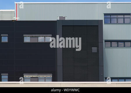 Un bâtiment industriel moderne avec différentes façades métalliques et les grilles. Banque D'Images