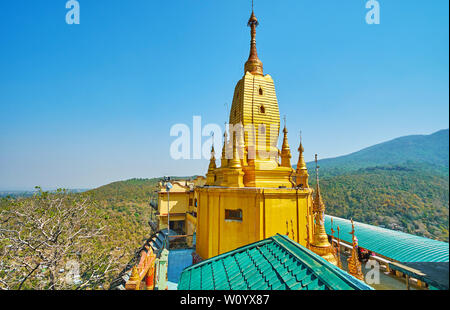 La pittoresque pagode dorée de Popa Taung Kalat monastère avec hti parapluie sur son haut et le paysage vallonné de Pégou gamme autour d'elle, au Myanmar Banque D'Images