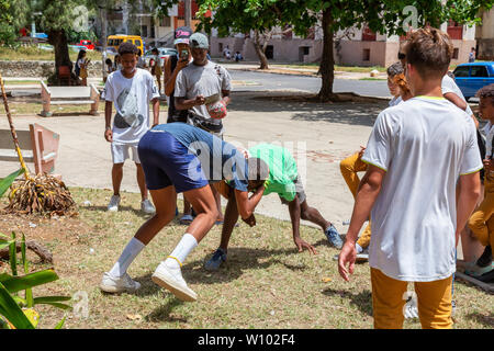 La Havane, Cuba - 14 mai 2019 : les jeunes adolescents la lutte et s'amusant dans une place publique durant une chaude journée ensoleillée. Banque D'Images