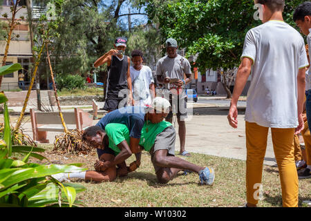 La Havane, Cuba - 14 mai 2019 : les jeunes adolescents la lutte et s'amusant dans une place publique durant une chaude journée ensoleillée. Banque D'Images