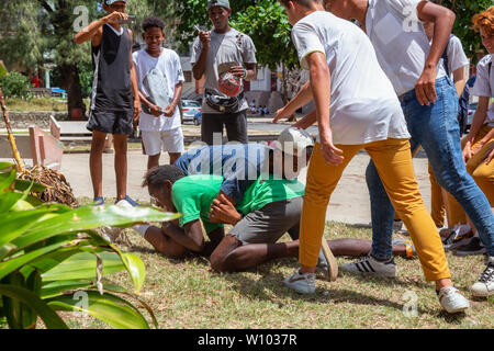 La Havane, Cuba - 14 mai 2019 : les jeunes adolescents la lutte et s'amusant dans une place publique durant une chaude journée ensoleillée. Banque D'Images