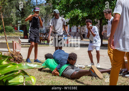 La Havane, Cuba - 14 mai 2019 : les jeunes adolescents la lutte et s'amusant dans une place publique durant une chaude journée ensoleillée. Banque D'Images