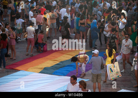 Les gens se rassemblent autour d'une grande fierté d'un drapeau au cours d'une manifestation pour célébrer la Journée internationale de la fierté, 2019 LGTBI organisé par l'andalousie Fédération Arc-en-ciel.Des milliers de personnes à travers le monde participent à la fierté, LGTBI marqué l'anniversaire des 50 ans de Stonewall riot qui a commémoré la lutte des gays, lesbiennes, bisexuels, transgenres et les démonstrations au cours de la première en nous en faveur de leurs droits. Banque D'Images