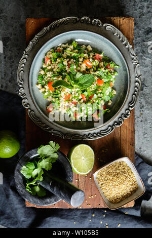 Végétarien salade rafraîchissante taboulé de boulgour, avec le persil, la menthe, les tomates et l'assaisonnement Banque D'Images