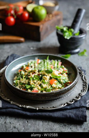 Végétarien salade rafraîchissante taboulé de boulgour, avec le persil, la menthe, les tomates et l'assaisonnement Banque D'Images
