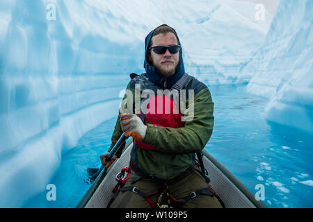 Grimpeur sur glace concentré sur paddling par un étroit canyon de glace sur le dessus de la Matanuska Glacier en Alaska. Banque D'Images