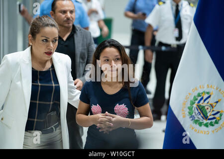 San Salvador, El Salvador. 28 Juin, 2019. Tania Avalos (r), veuve et mère d'un homme âgé de 25 ans qui est mort avec ses 23 mois, en essayant de traverser le Rio Bravo le long de la frontière entre le Mexique et les Etats-Unis, s'agit d'une conférence de presse à Mgr Oscar Arnulfo Romero Aéroport International. L'athlète de 21 ans est revenu au pays cet après-midi. Crédit : Carlos Barrera/dpa/Alamy Live News Banque D'Images