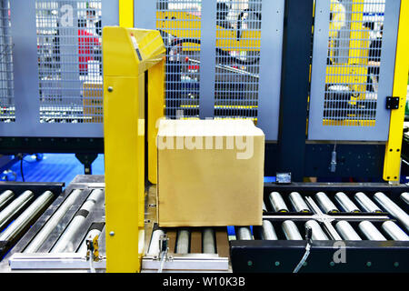 Boîtes de carton sur la courroie du convoyeur en entrepôt de distribution.colis de transport du concept. Banque D'Images