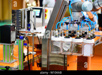 Le bras robot de verre disposés sur la bouteille d'eau dans l'équipement automatique de machines industrielles factory de la ligne de production Banque D'Images