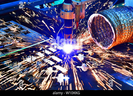 Machine de coupe laser industriel tout en réduisant la tôle avec les étincelles de lumière. Banque D'Images
