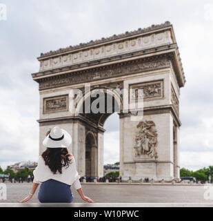 Jeune voyageur woman in white hat à Arc de Triomphe, célèbre monument et destination touristique dans Paris, France en été Banque D'Images