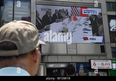 Osaka, Japon. 29 Juin, 2019. Un homme s'arrête pour écouter une nouvelle mise à jour de la réunion du G20 entre le Président Donald Trump et le président chinois Xi Jinping a été diffusé à Namba à Osaka au Japon. Le même jour, présidents, premiers ministres et autres hauts responsables du monde entier se sont réunis pour la deuxième journée du sommet du G20 d'Osaka. Photo prise le samedi, 29 juin 2019. Photo par : Ramiro Agustin Vargas Tabares Crédit : Ramiro Agustin Vargas Tabares/ZUMA/Alamy Fil Live News Banque D'Images