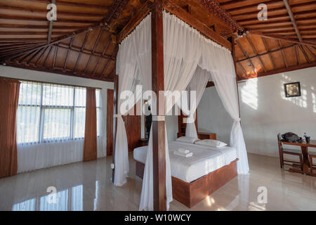 L'Est de Java, Indonésie - 10 Sep 2018 : chambre à coucher en bois l'architecture de style balinais avec rideau de tropical villa de luxe Banque D'Images
