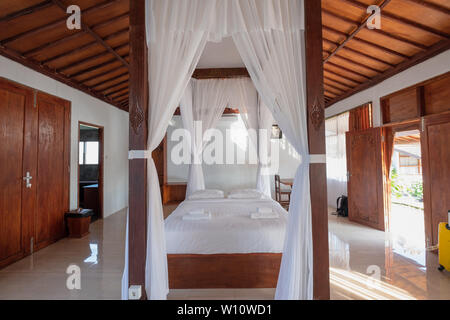 L'Est de Java, Indonésie - 10 Sep 2018 : chambre à coucher en bois l'architecture de style balinais avec rideau de tropical villa de luxe Banque D'Images